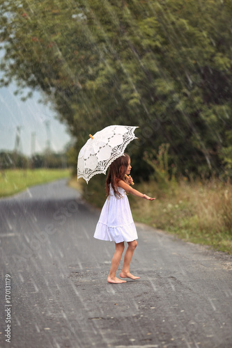 Dancing young girl in summer rain © ambrozinio