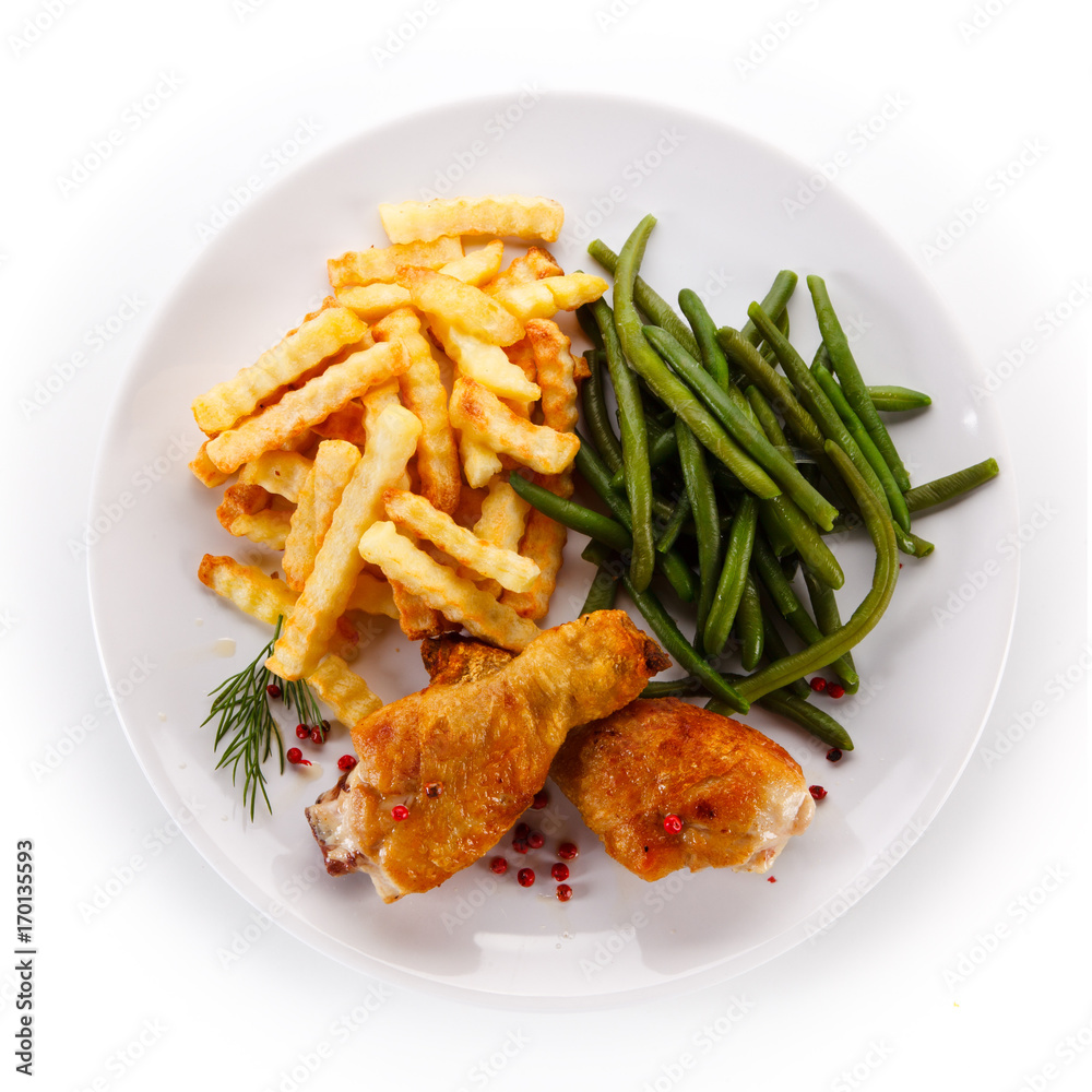 Grilled drumsticks with french fries and vegetables Grilled drumsticks with french fries and vegetables