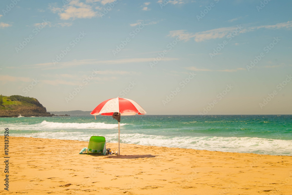 green beach chair was put underneath the red-white strip umbrella (vintage theme)
