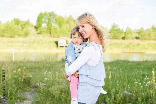 Mom and sad little charming daughter. family resting in nature. mother cares about her baby daughter
