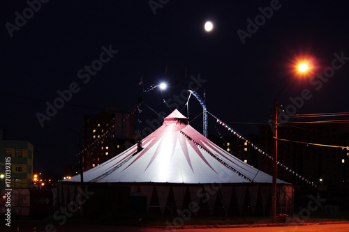 gloomy tent of terrible circus at night in the wasteland.