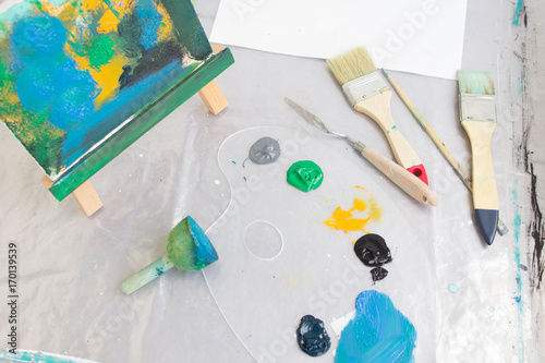 Messy painter workplace top view. Art studio. Creative hobby for children, abstract painting, craft tools, artistic concept