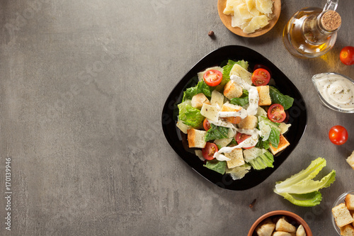 Fototapeta caesar salad and ingredients at table