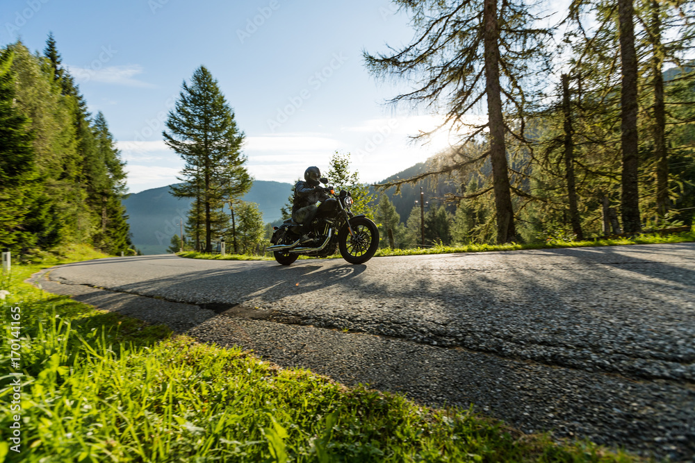 Naklejka premium Motorcycle driver riding in Alpine highway, Nockalmstrasse, Austria, Europe.