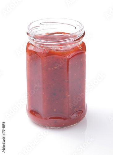 tomato sauce in glass jar on white