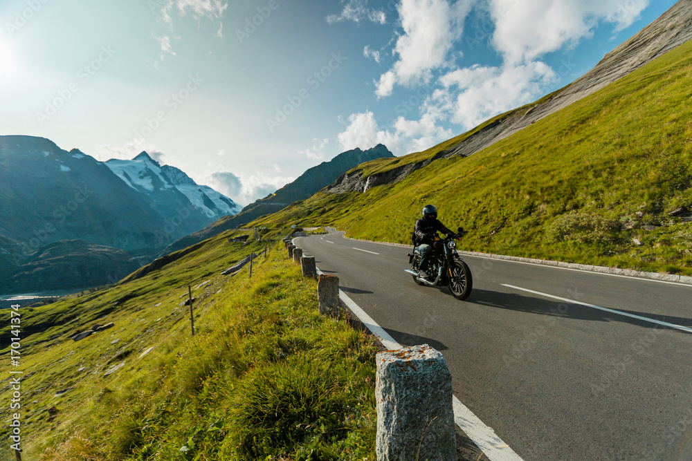 Fototapeta premium Motorcycle driver riding in Alpine highway on famous Hochalpenstrasse, Austria, Europe.
