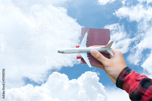 Tourist holding airplane and passport flight travel traveller fly on the blue sky for travelling citizenship air on the around world.  Travel Concept.