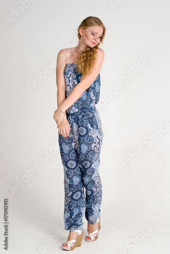 Beautiful romantic girl blonde in summer dress with orchid flower
