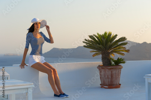 Santorini travel tourist brunette woman visiting famous white Oia village. photo