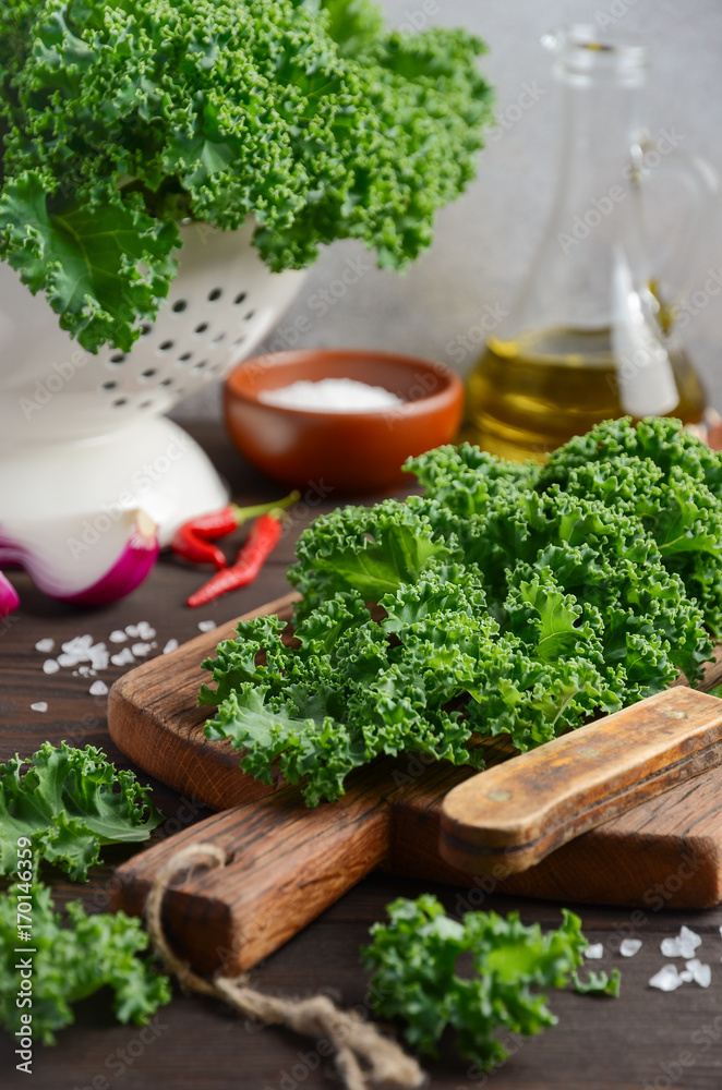 Fresh green kale with olive oil and spices, ready for cooking, selective focus Fresh green kale with olive oil and spices, ready for cooking, selective focus