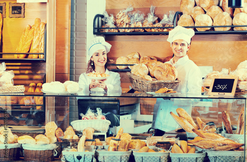 Portrait of charming positive smiling couple at bakery display