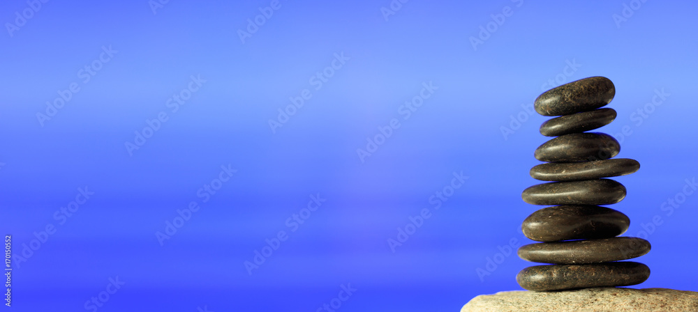 Obraz premium Zen stones stack on blue sea background