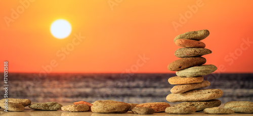 Zen stones stack on sea background at sunset