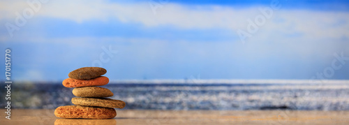 Photography Zen stones stack on blue sky and sea background