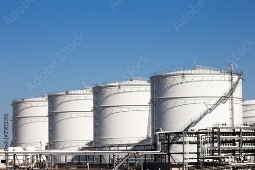 Row of large white oil storage tank silo's 
