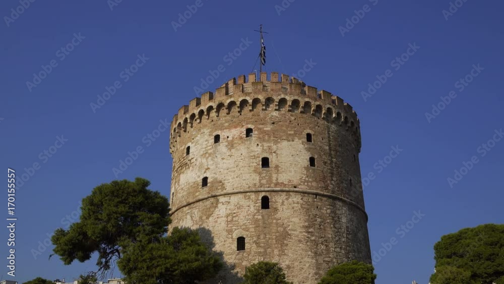 Thessaloniki, Greece. The White Tower, the landmark of the city, with Greek flag waving on top. Thessaloniki, Greece. The White Tower, the landmark of the city, with Greek flag waving on top.