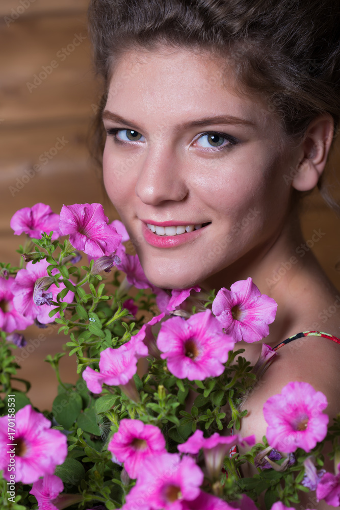 Beautiful young woman holding a pot of ampel Petunia flowers Beautiful young woman holding a pot of ampel Petunia flowers