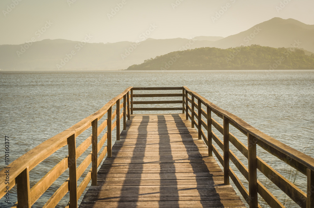 Bonito deck em lagoa sem ninguém, vista tranquila.