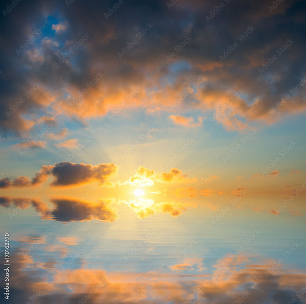 The sun rises from behind the sea, the rays from the sun in the clouds. The sun rises from behind the sea, the rays from the sun in the clouds.