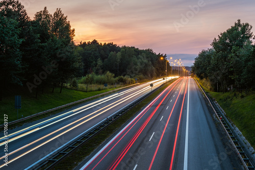 Speed traffic on highway at dusk. Colorful light trails on the street. Poland.