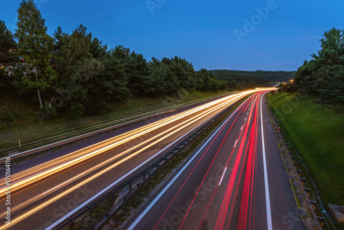 Speed traffic on highway at dusk. Colorful light trails on the street. Poland.