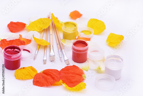 Flower leaves with gouache on white table. photo