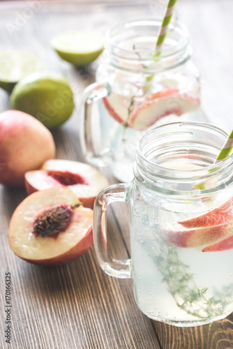 Glass jar of lime water with slices of peach