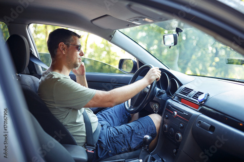 modern man driving in the car and talking on phone.