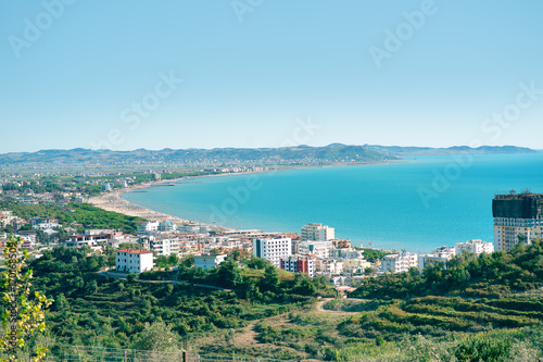 Aerial view to turquoise waters of Adriatic Sea close to Durres in central Albania. Golem zone. Green hills and sandy beach line.