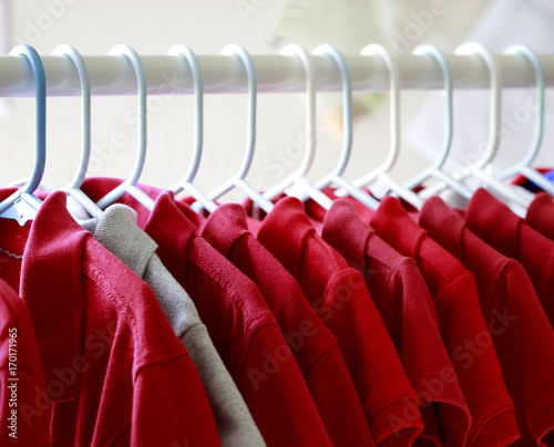 Photo Red and one gray school uniform shirts on hangers