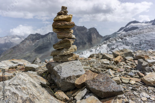 Fototapete A beautiful cairn with mountains and a glacier in the background in the alps of switzerland
