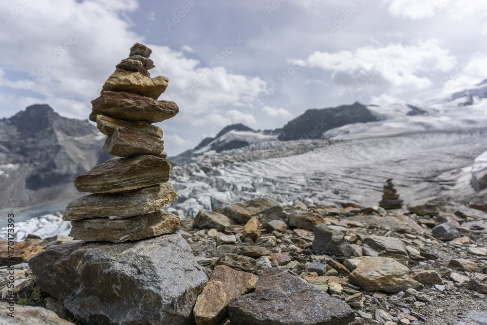 A beautiful cairn with mountains and a glacier in the background in the alps of switzerland. A beautiful cairn with mountains and a glacier in the background in the alps of switzerland.