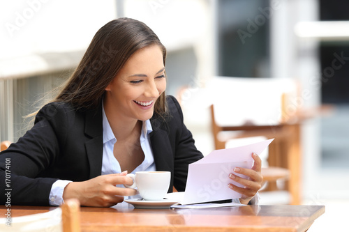 Businesswoman reading a letter in a coffee shop