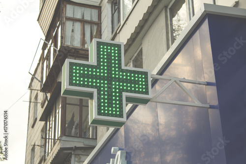 Pharmacy Neon Sign. Green сross sign on the building. Pharmacy concept. Drug store.