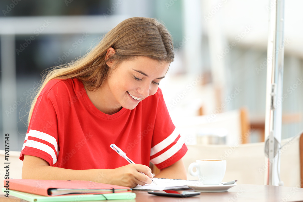 Happy student girl taking notes in a bar Happy student girl taking notes in a bar