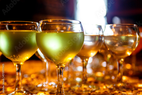 Green lemonade or cocktail in glass wine glasses.