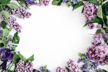 Frame of lilac flowers, branches, leaves and petals with space for text on white background. Flat lay, top view