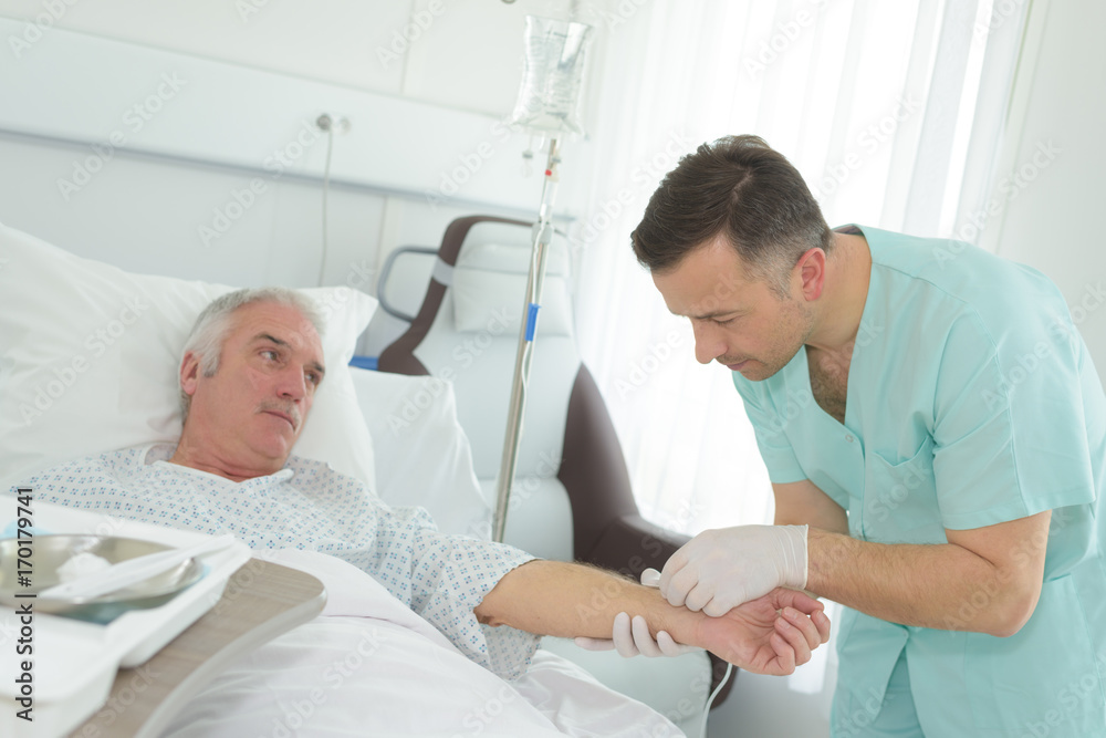 Obraz premium nurse measuring blood pressure disabled man