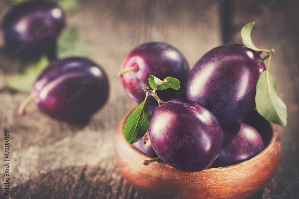 Foto Plum. Juicy ripe organic plums closeup, over wooden background