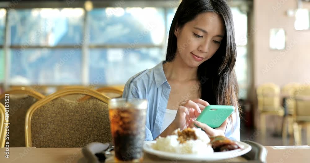 Woman using mobile phone in restaurant Woman using mobile phone in restaurant