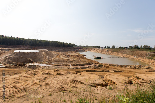 Mining in a sand quarry with powerful machines and a washing lake