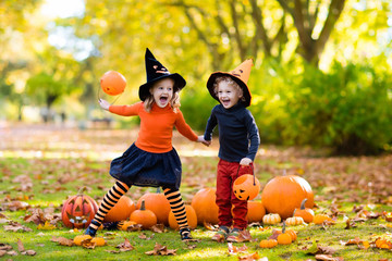 Kids with pumpkins in Halloween costumes