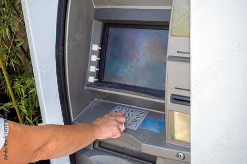 Young woman withdrawing money from credit card at ATM