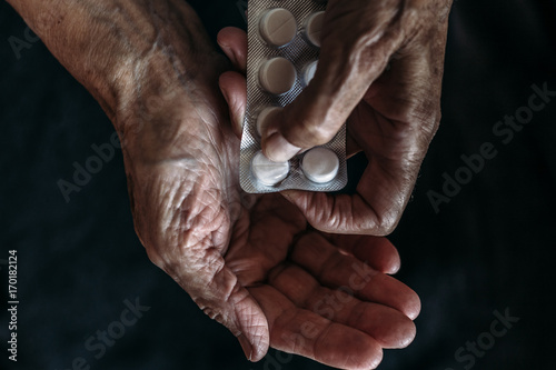 Hands of old woman with tablets or pills. Health care and Taking medication of old people
