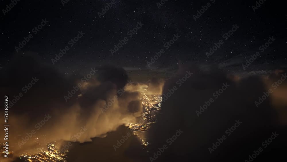 Flying over the deep night timelapse clouds with dark sky. Seamlessly looped animation. Flight through moving cloudscape over night city lights. Perfect for cinema, background, digital composition.