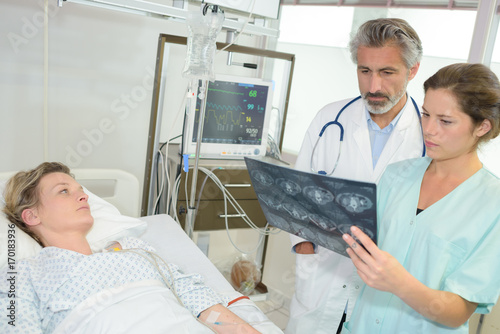 doctors examining patients xray in hospital room