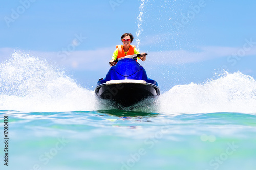 Teenager on water scooter. Teen age boy water skiing. © famveldman
