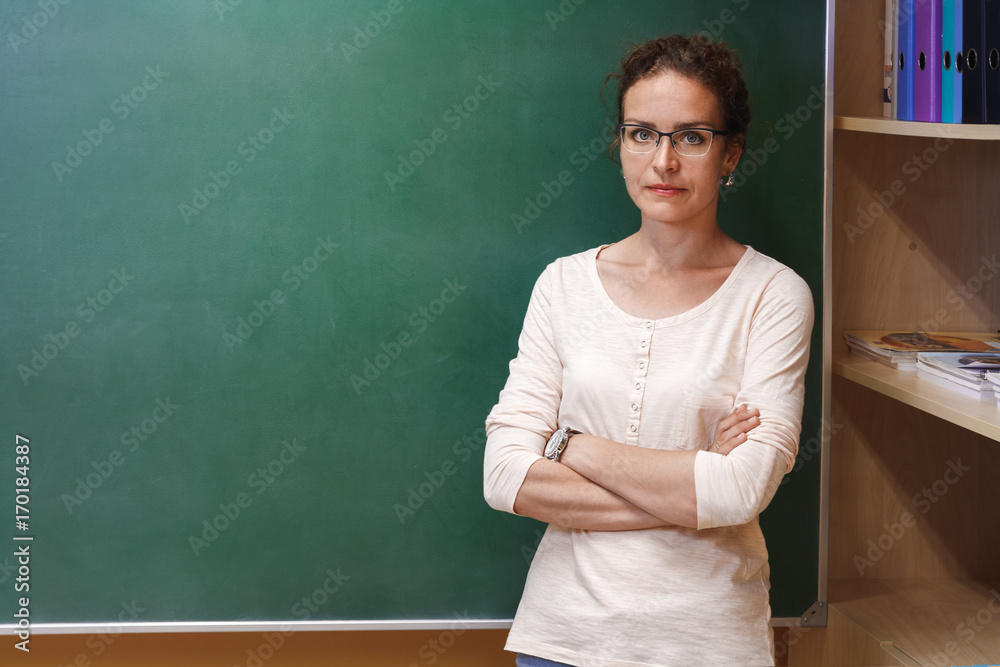 Portrait of a female teacher near the school blackboard Portrait of a female teacher near the school blackboard