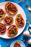  Sweet potato toast with beet hummus, grilled chickpeas, fresh parsley, nigella seeds  and sunflower seeds on a plate on a blue table, top view. A nutritious and delicious vegan meal