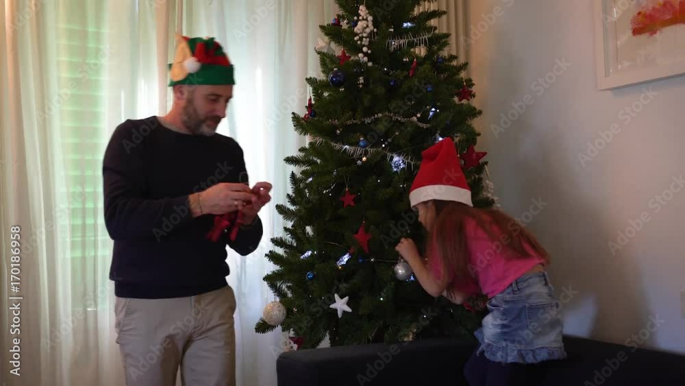 Father and daughter undoing the Christmas tree together, selective focus Father and daughter undoing the Christmas tree together, selective focus